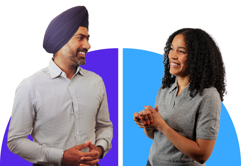 A man in a striped shirt and turban chats with a woman in a gray top, both smiling